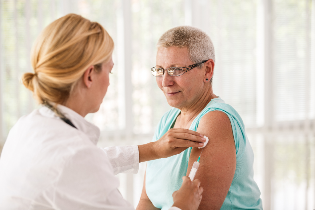 Older adult receiving a pneumococcal vaccine injection from a healthcare provider.