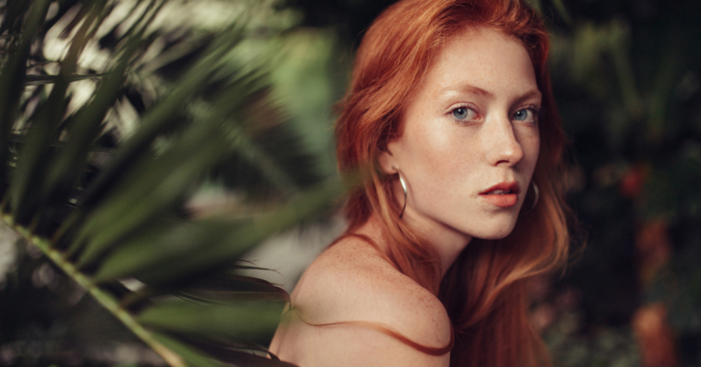 Portrait of a woman with glowing skin, surrounded by greenery, symbolizing natural skincare and wellness solutions for hormonal acne.