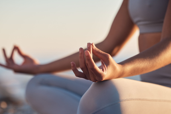 Close-up of a woman meditating outdoors, using mindfulness and stress management techniques to prevent hair loss.