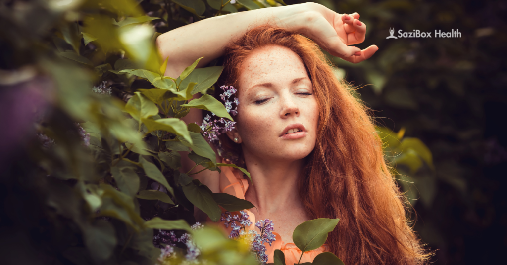 A woman with thick, vibrant red hair standing in lush greenery, symbolizing natural remedies for healthy hair and hair loss recovery.