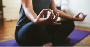 A woman practicing mindfulness through yoga for natural relief from anxiety symptoms in women.