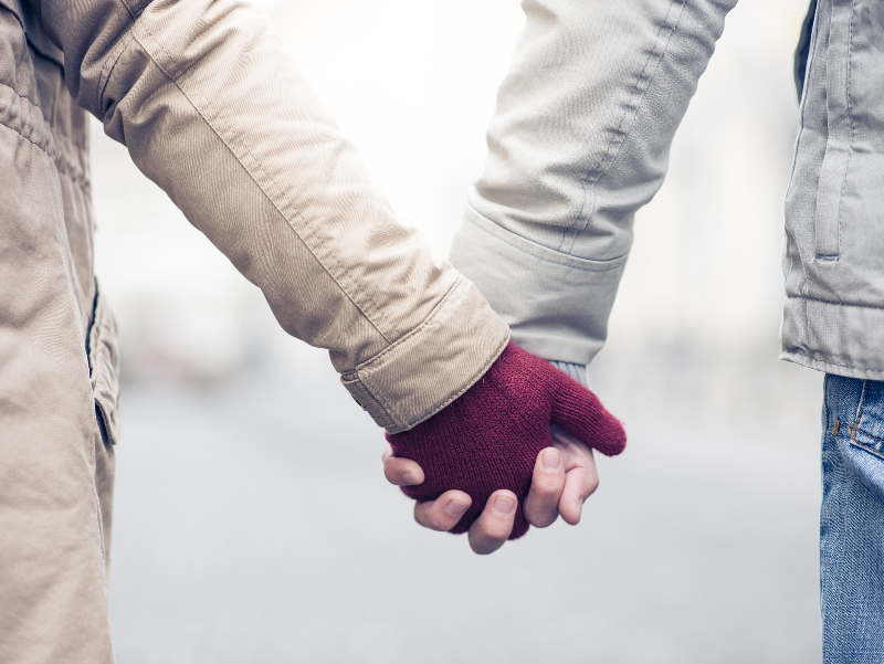 A couple holding hands, symbolizing trust, connection, and the emotional strength of a husband in a healthy marriage.