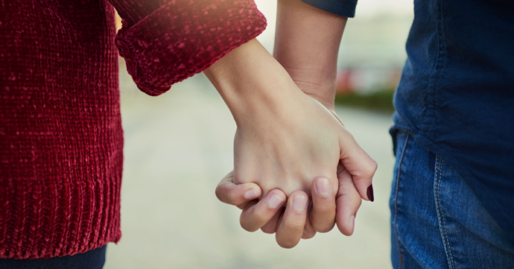 Close-up of a couple holding hands, symbolizing the qualities of an ideal wife like loyalty and trust in a relationship.