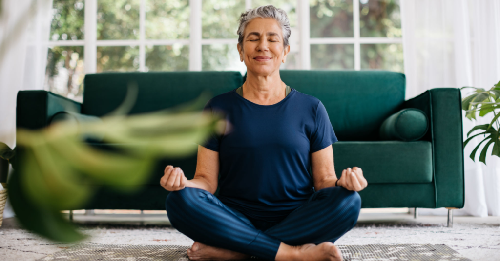 A mature woman practicing mindfulness meditation as part of vitality tips for women to manage stress.