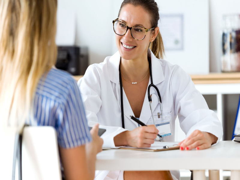 A woman talking to a doctor during a medical appointment, emphasizing the importance of regular health check-ups.