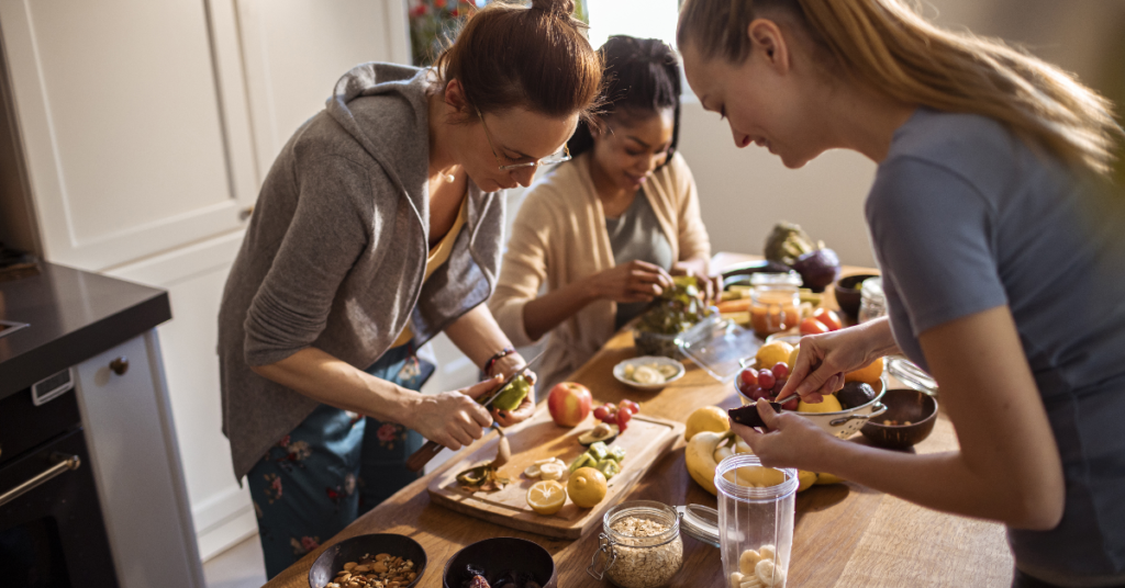 Women preparing healthy meals with fruits, vegetables, and nuts, promoting thyroid wellness and natural solutions.