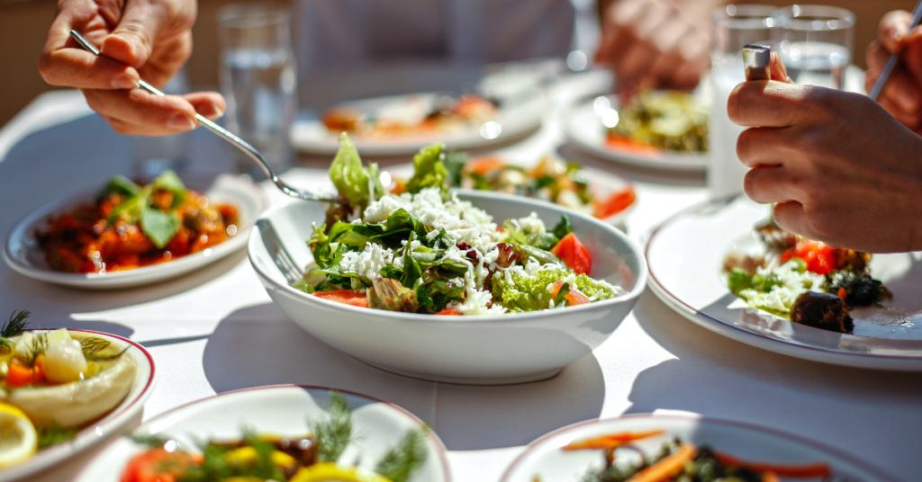 Plates of fresh salads and vegetables on a table, illustrating healthy meal ideas.