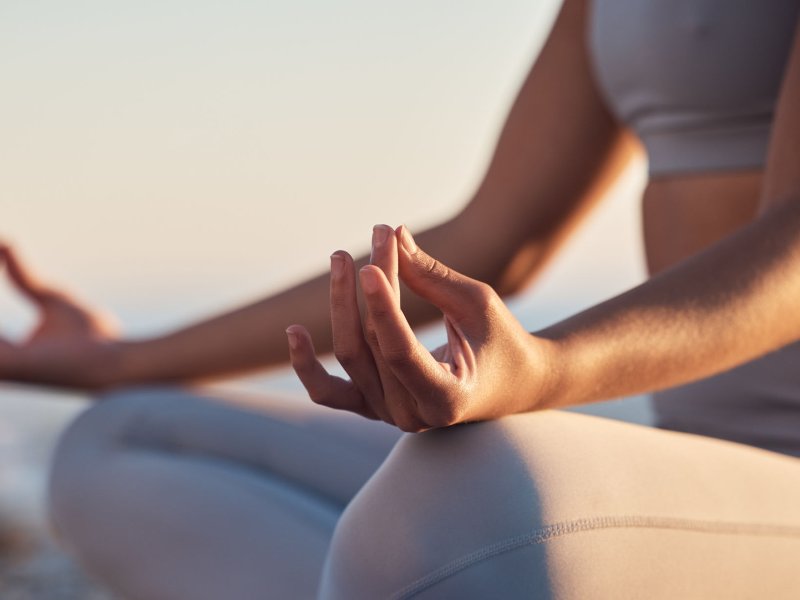 A woman meditating outdoors, practicing mindfulness to balance hormones naturally.