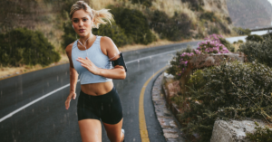 Woman running outdoors as part of a cardio workout to balance hormones and improve health.