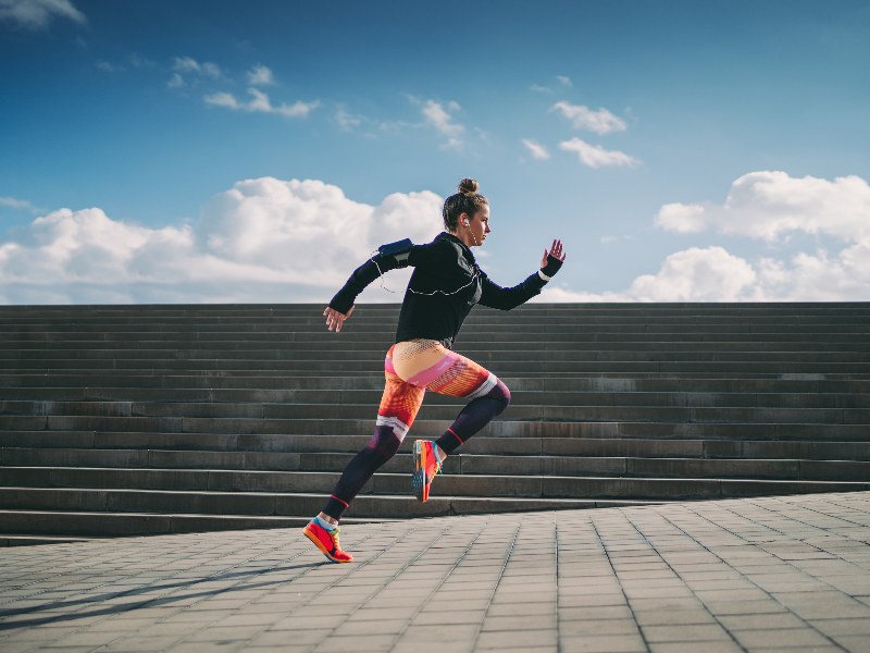 A woman sprinting outdoors, demonstrating HIIT for hormonal health and fitness.